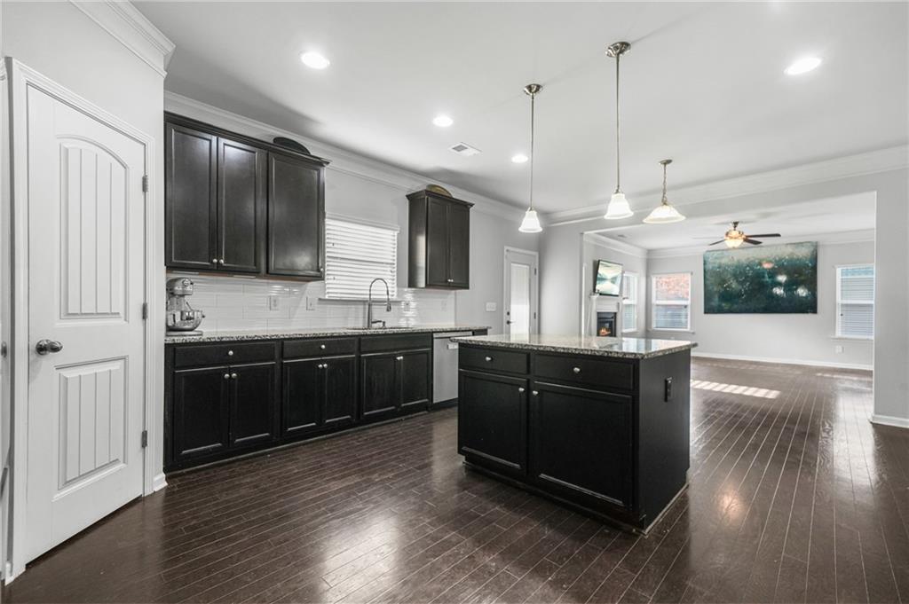 200 Cherokee Reserve Circle Canton, GA 30115 - Photo 17 of 50 a large kitchen with stainless steel appliances kitchen island granite countertop a stove a sink a refrigerator and a wooden floor