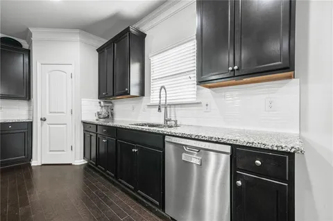 a kitchen with granite countertop cabinets stainless steel appliances and a sink