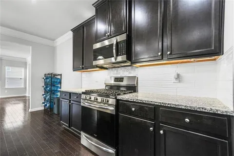 a kitchen with stainless steel appliances granite countertop a stove a sink and a microwave