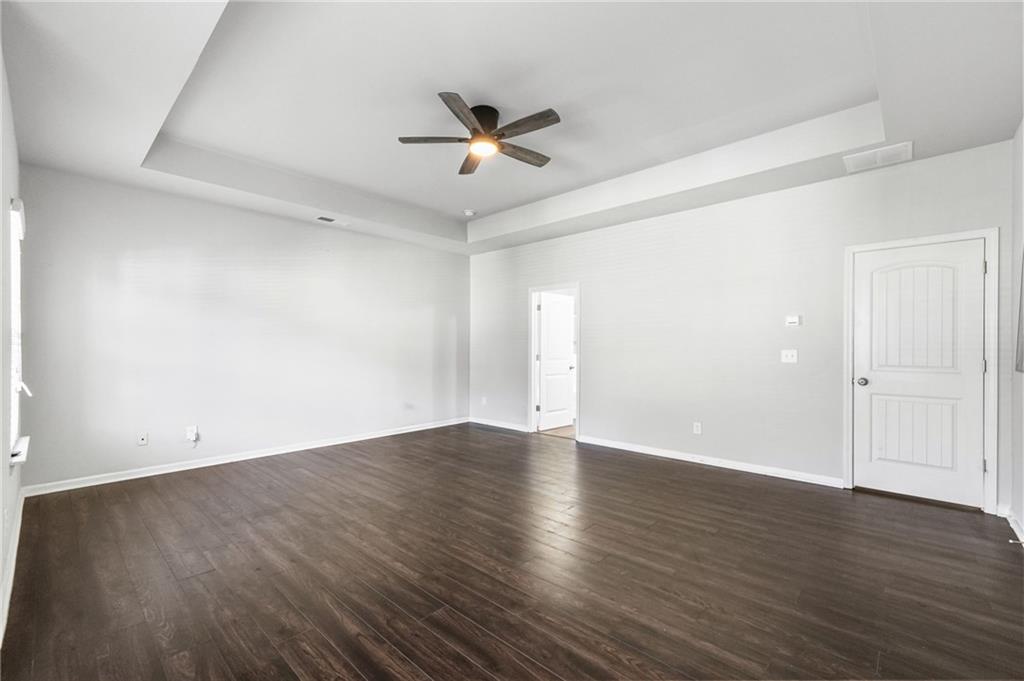 200 Cherokee Reserve Circle Canton, GA 30115 - Photo 29 of 50 an empty room with wooden floor a ceiling fan and windows