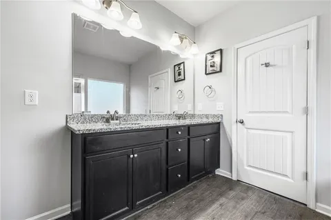 a bathroom with a granite countertop sink and a mirror