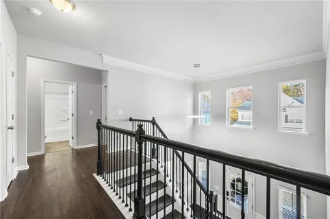 a view of a hallway with wooden floor and stairs