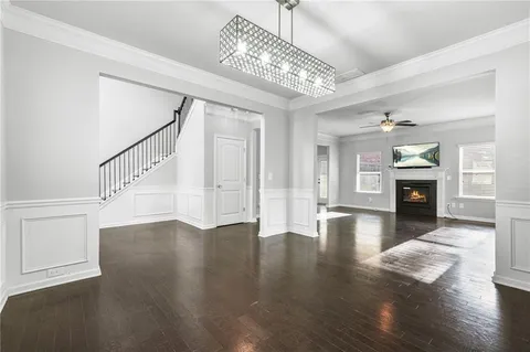 a view of a livingroom with wooden floor and a kitchen