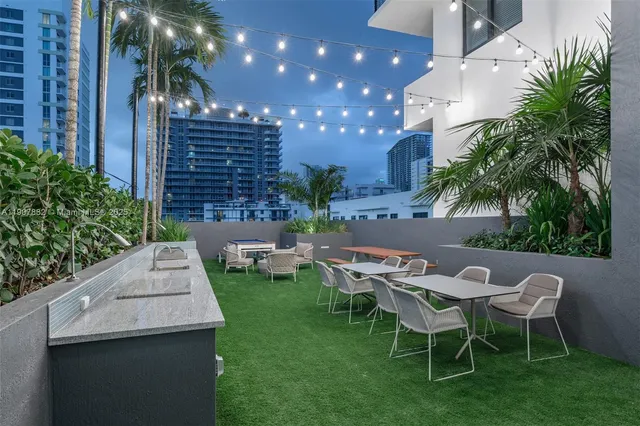 a view of a patio with couches table and chairs and potted plants
