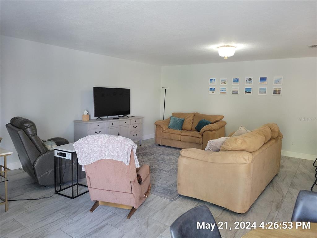 1013 Apollo Beach Boulevard, Unit 101 Apollo Beach, FL 33572 - Photo 6 of 19 a living room with furniture and a flat screen tv