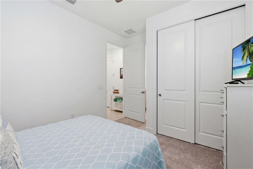 18364 Ridgeline Drive Estero, FL 33928 - Photo 26 of 50 a bedroom with a bed and a flat screen tv