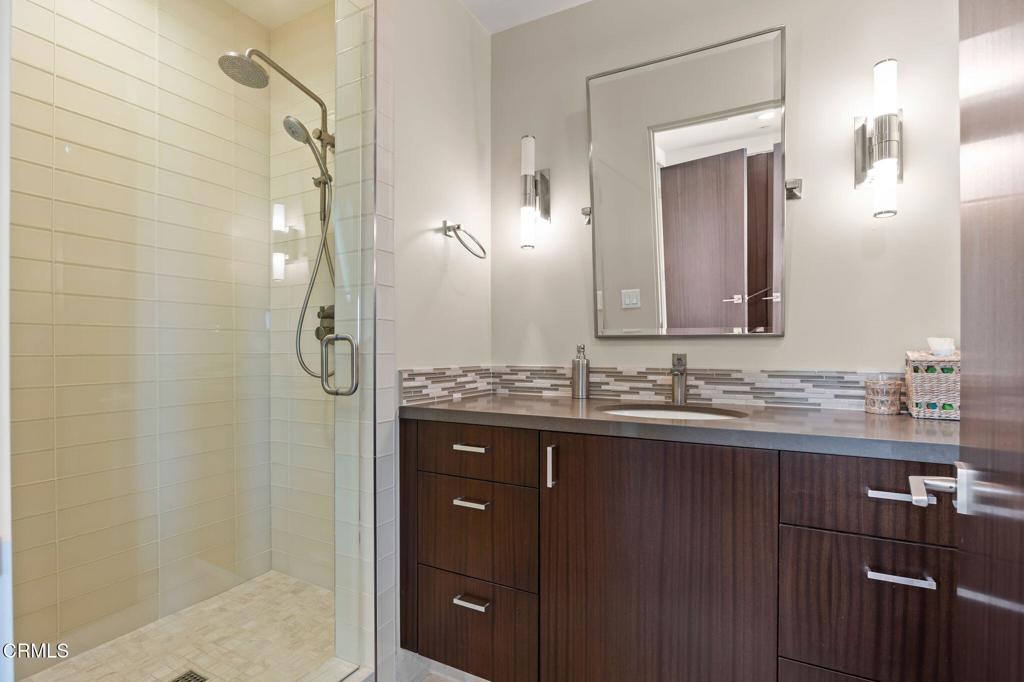 1409 Marine Way Oxnard, CA 93035 - Photo 43 of 58 a bathroom with a granite countertop sink a mirror and a shower