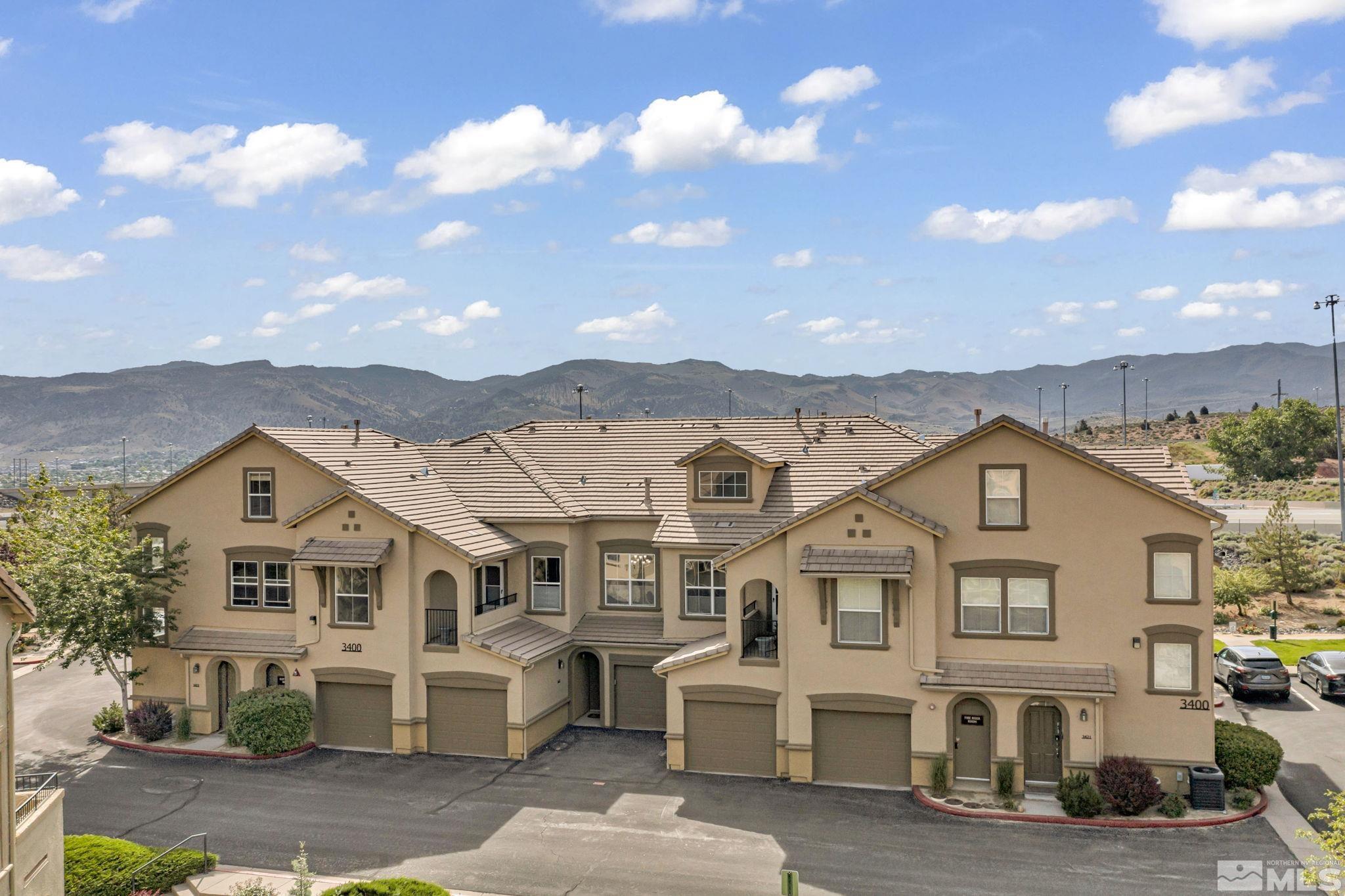 17000 Wedge Parkway, Unit 3422 Reno, NV 89511 - Photo 1 of 39 a view of a big house with a big yard and large trees