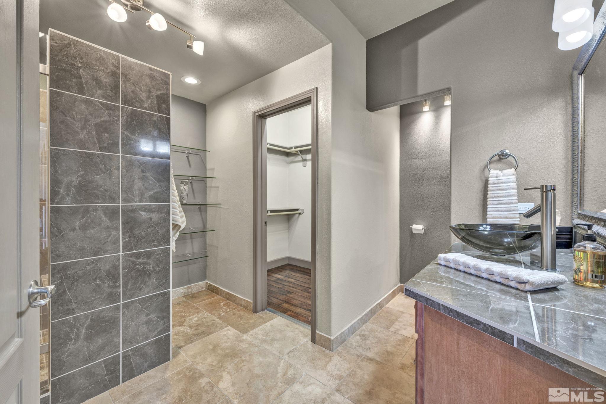 17000 Wedge Parkway, Unit 3422 Reno, NV 89511 - Photo 21 of 39 a bathroom with a granite countertop sink a mirror and shower