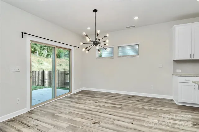 a view of a room with wooden floor and windows