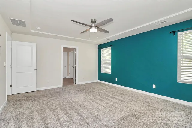 a view of an empty room with a window and a ceiling fan