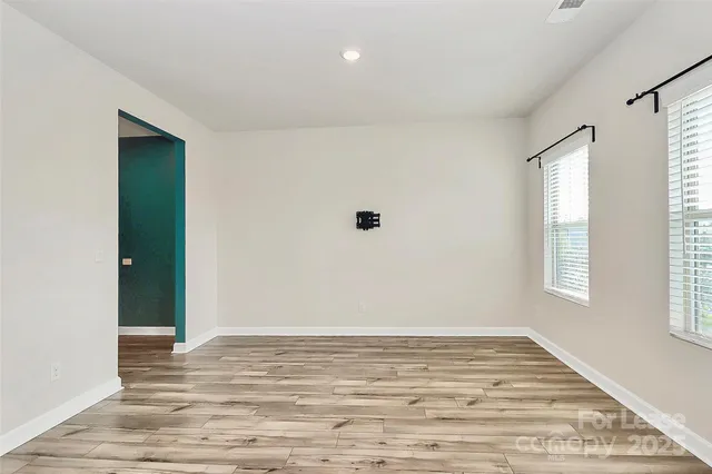 a view of a room with wooden floor and window