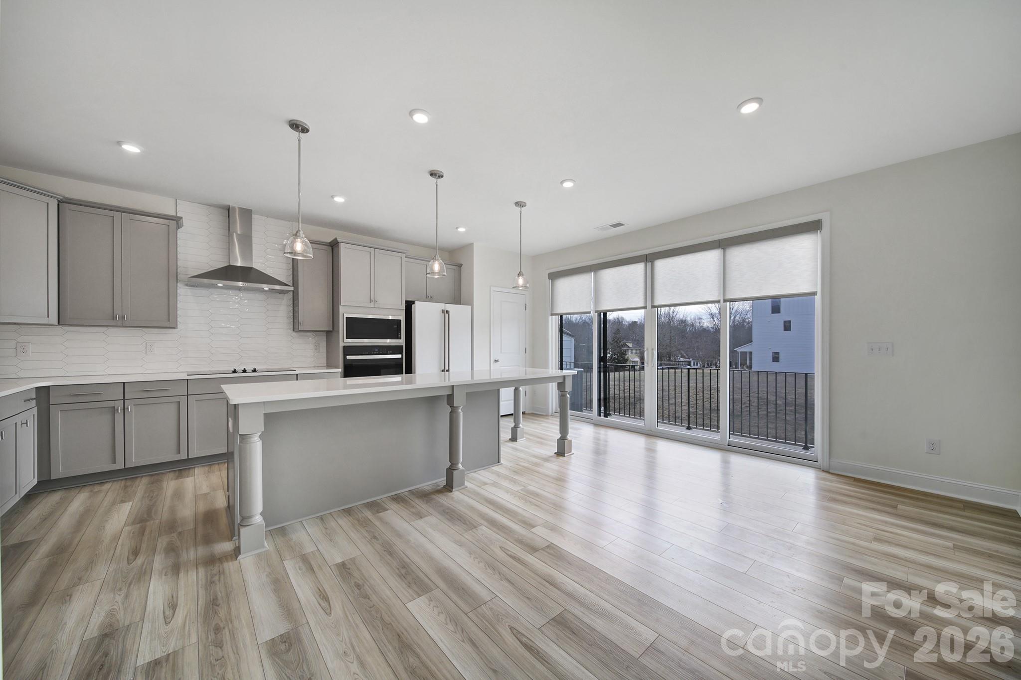 643 District Court Fort Mill, SC 29708 - Photo 11 of 41 a large kitchen with stainless steel appliances a large counter top and wooden floors