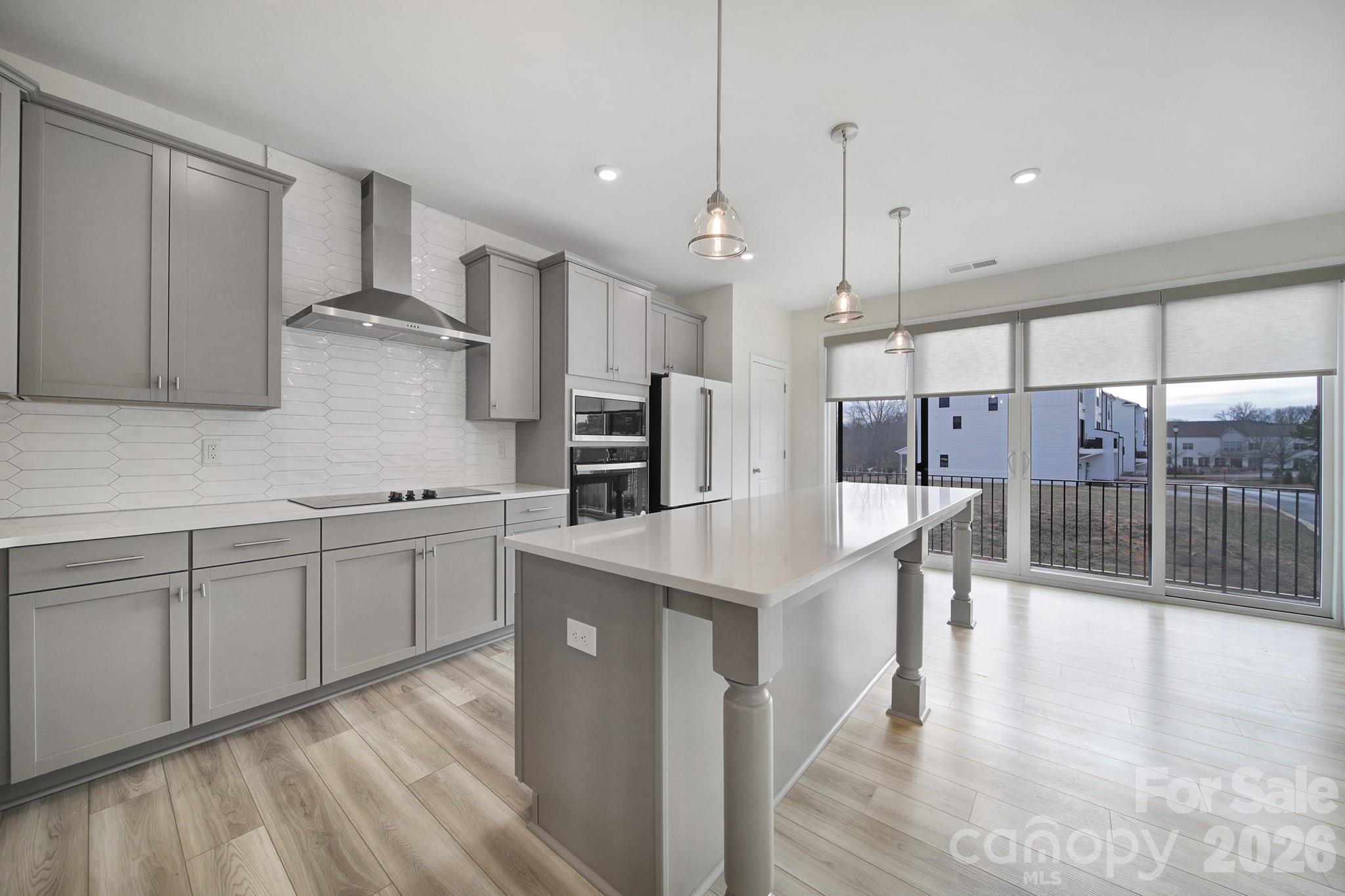 643 District Court Fort Mill, SC 29708 - Photo 14 of 43 a kitchen with stainless steel appliances kitchen island granite countertop a table chairs refrigerator and microwave