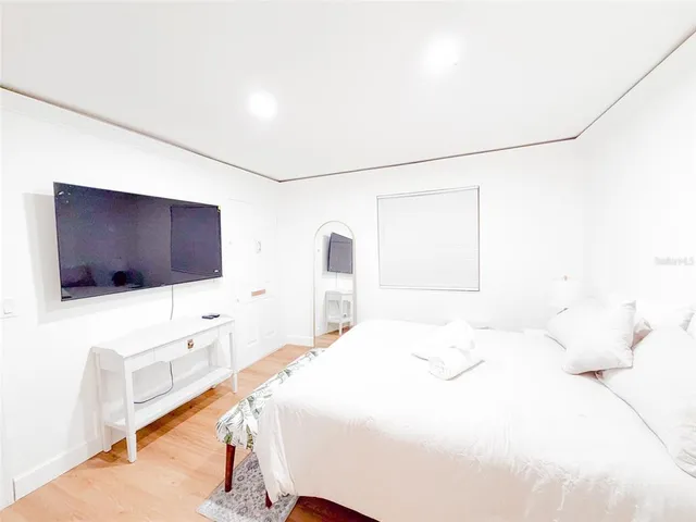 a bedroom with a bed and a flat screen tv