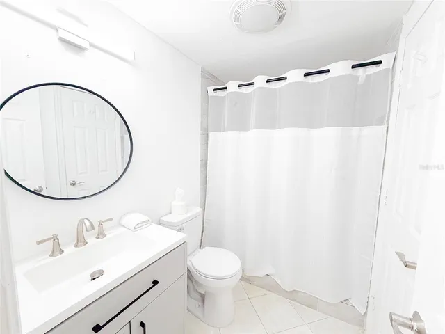 a bathroom with a sink vanity mirror and toilet