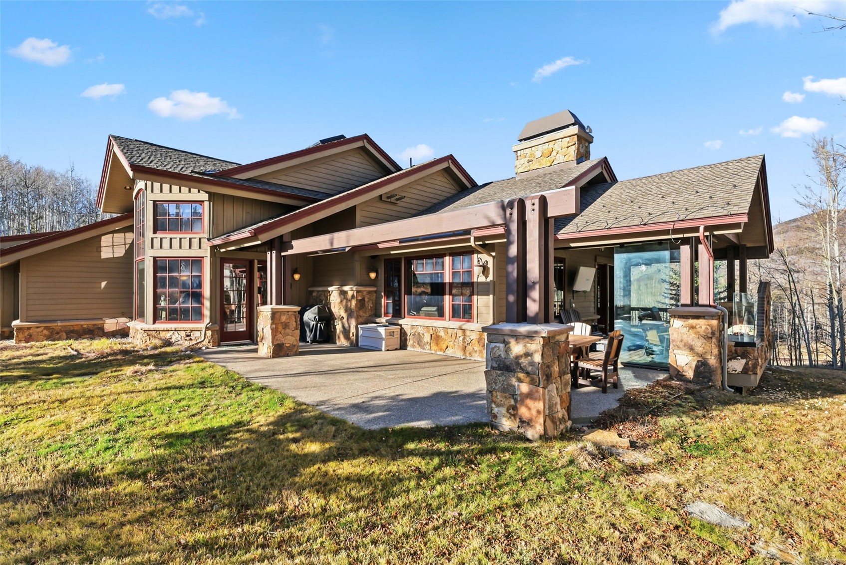 2140 Hunter's Knob Road Silverthorne, CO 80498 - Photo 38 of 46 Back of property with a patio area, a yard, a chimney, and stone siding