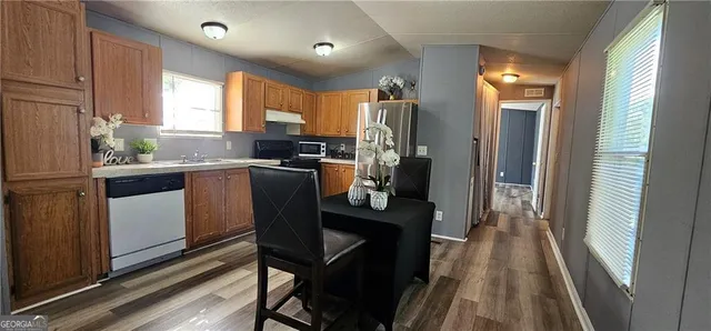 a kitchen with a table chairs refrigerator and microwave