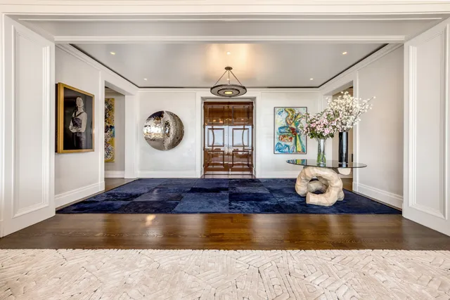 a living room with a wooden floor and chandelier