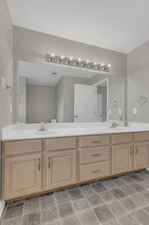 a spacious bathroom with a granite countertop double vanity and a mirror