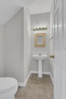 a bathroom with a sink a toilet and mirror