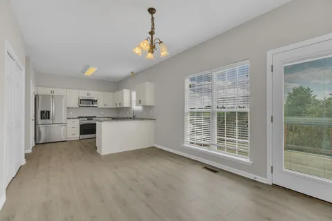 a view of an empty room with a kitchen