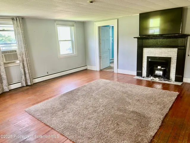 an empty room with windows and fireplace