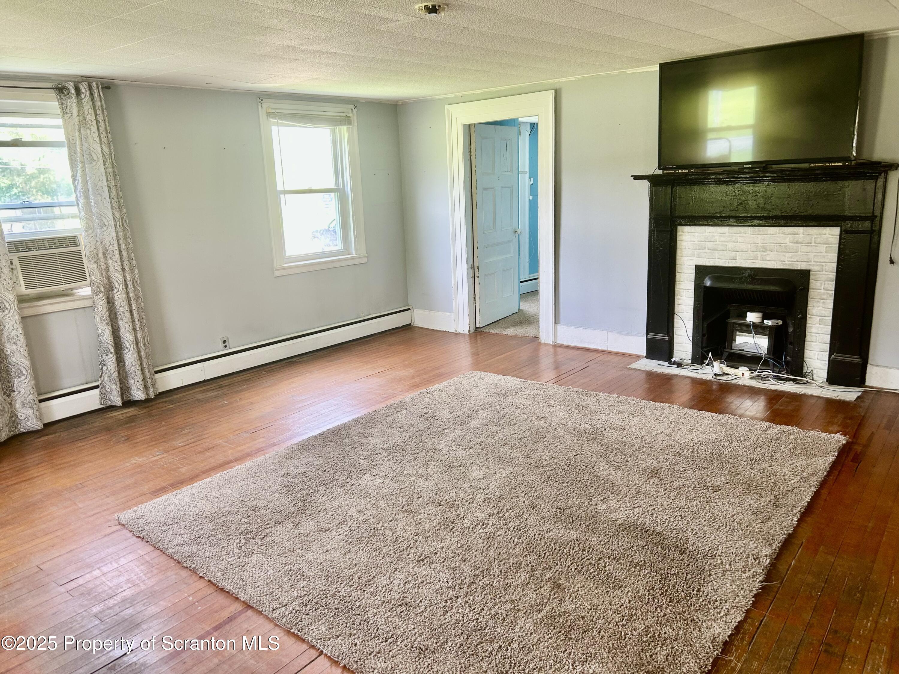 536 Old Rte 11 New Milford, PA 18834 - Photo 3 of 36 an empty room with windows and fireplace
