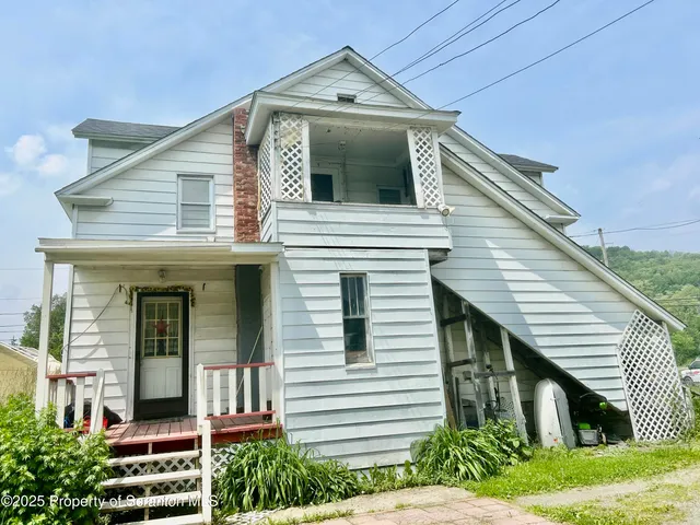 a view of a house with a big yard and large trees