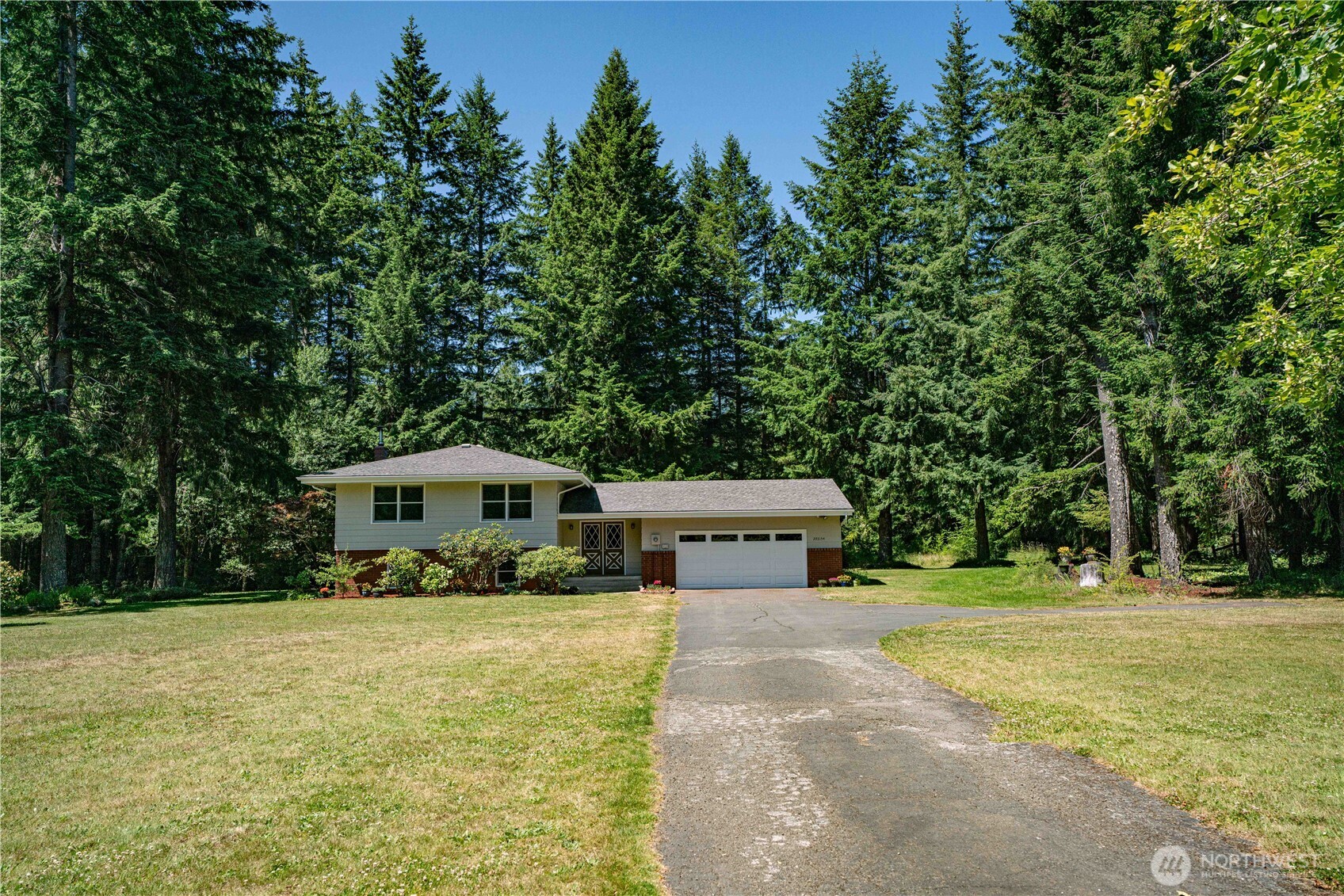293154 Highway 101 Quilcene, WA 98376 - Photo 2 of 40 a front view of a house with garden