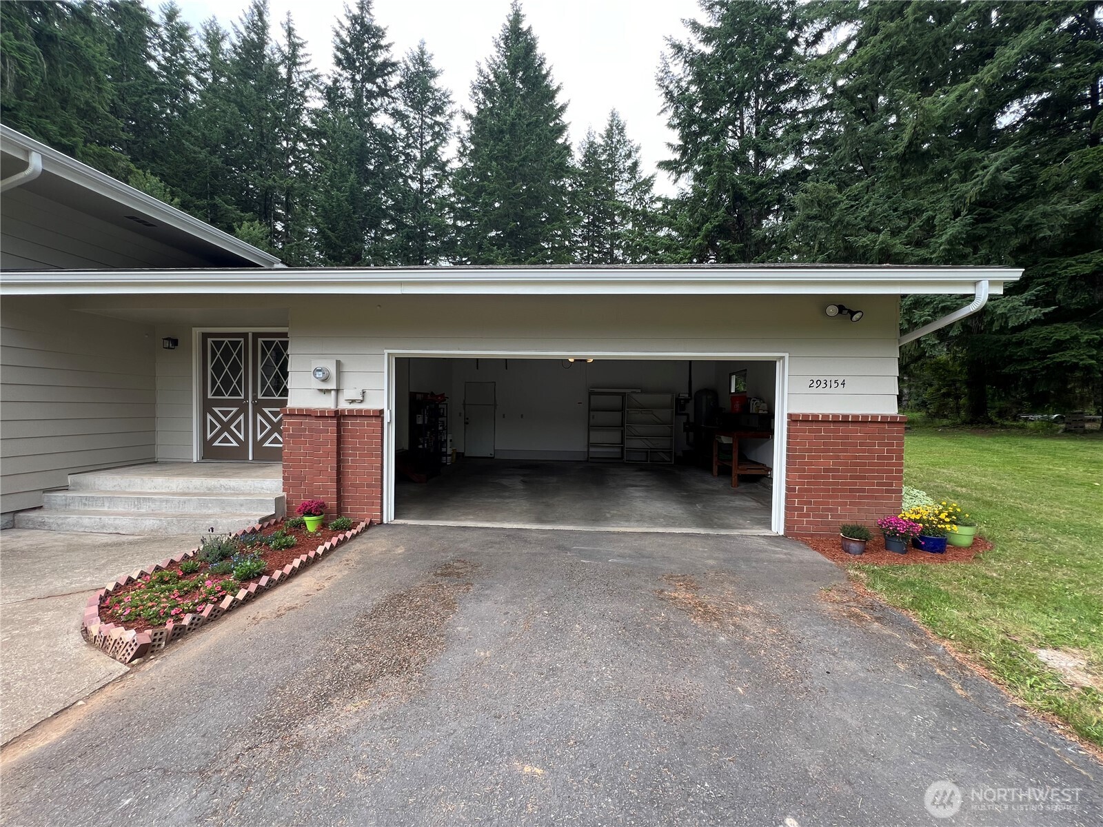 293154 Highway 101 Quilcene, WA 98376 - Photo 28 of 40 a front view of a house with a yard and garage