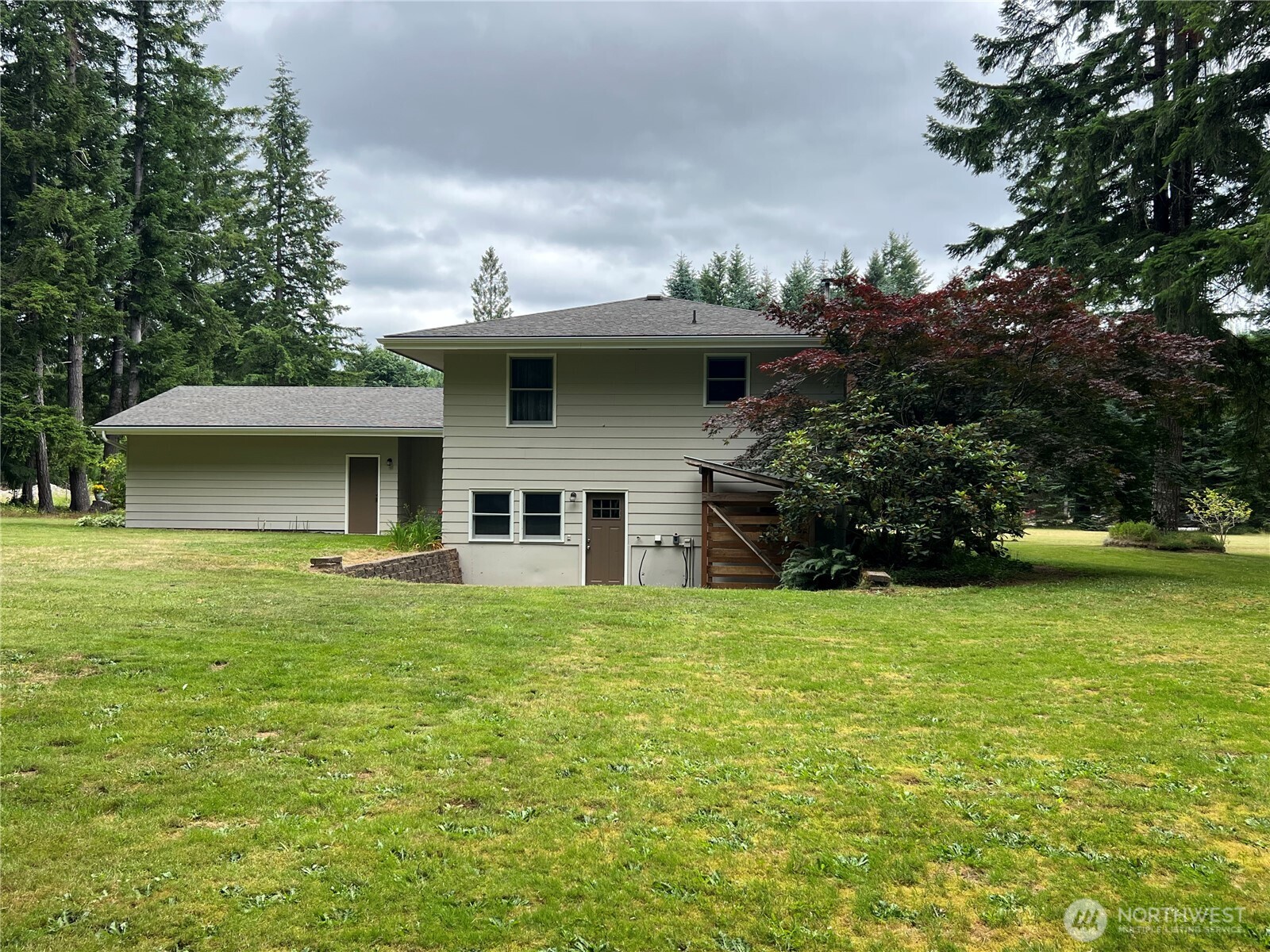293154 Highway 101 Quilcene, WA 98376 - Photo 29 of 40 a front view of a house with a garden