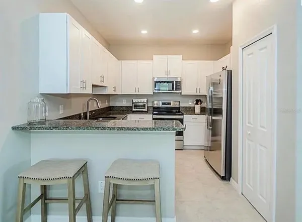 a kitchen with stainless steel appliances granite countertop a refrigerator sink and microwave