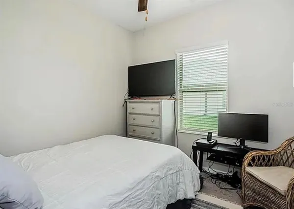 a bedroom with a bed and a flat screen tv