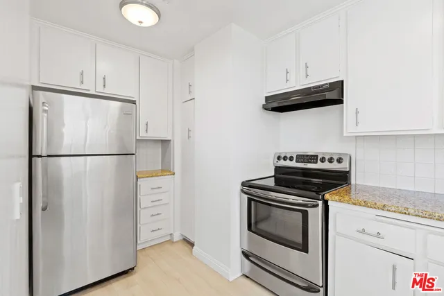 a kitchen with stainless steel appliances white cabinets and a stove