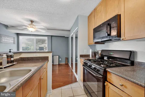 a kitchen with stainless steel appliances granite countertop a sink stove and microwave