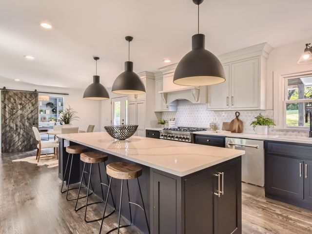 a kitchen with stainless steel appliances a sink a stove a refrigerator and cabinets