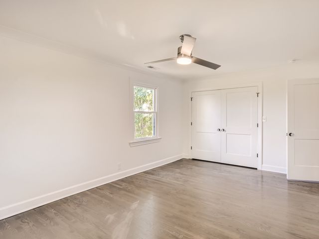 an empty room with a window and ceiling fan