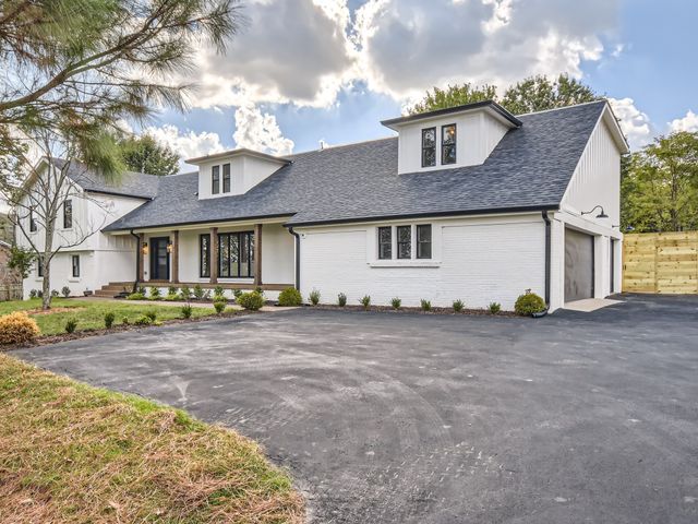 a front view of a house with a dirt yard and a garage