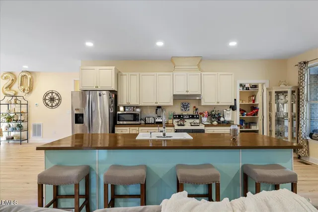 a kitchen with stainless steel appliances granite countertop a table and chairs