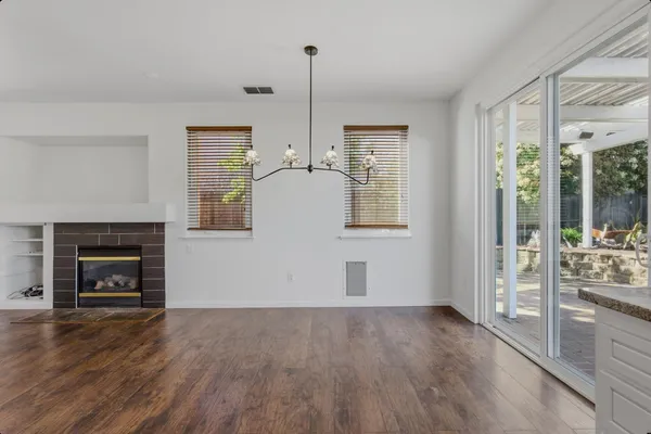 a view of empty room with wooden floor and fireplace