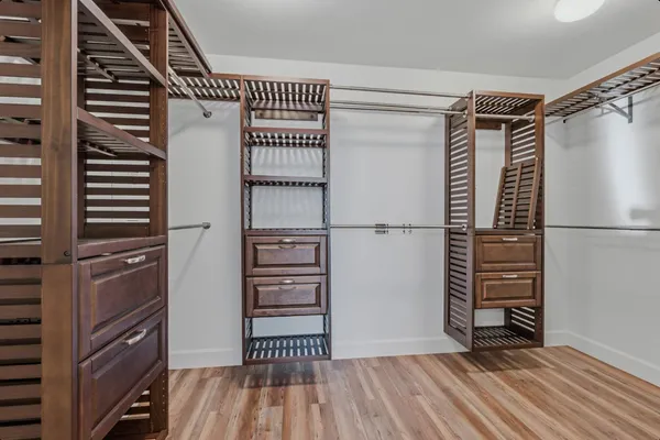 a view of walk in closet with wooden floor