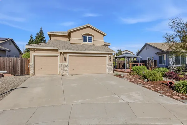 a front view of a house with a garage and a yard
