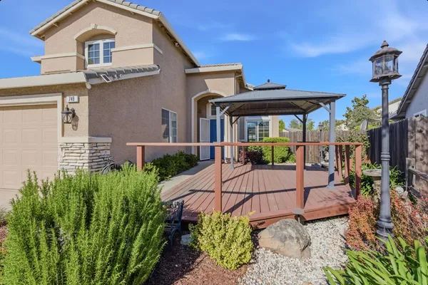 a view of a house with backyard and sitting area