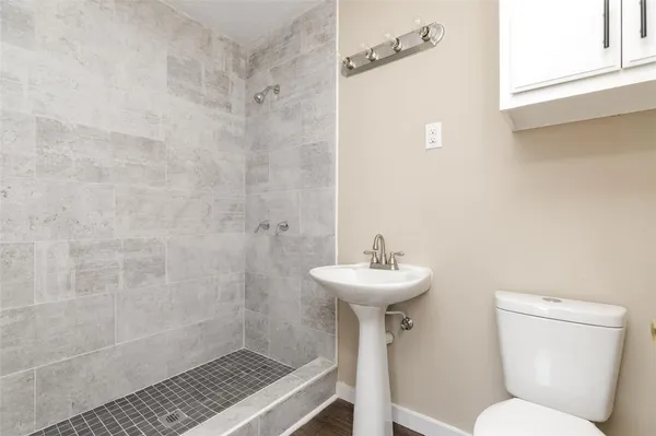 a bathroom with a sink a toilet and shower