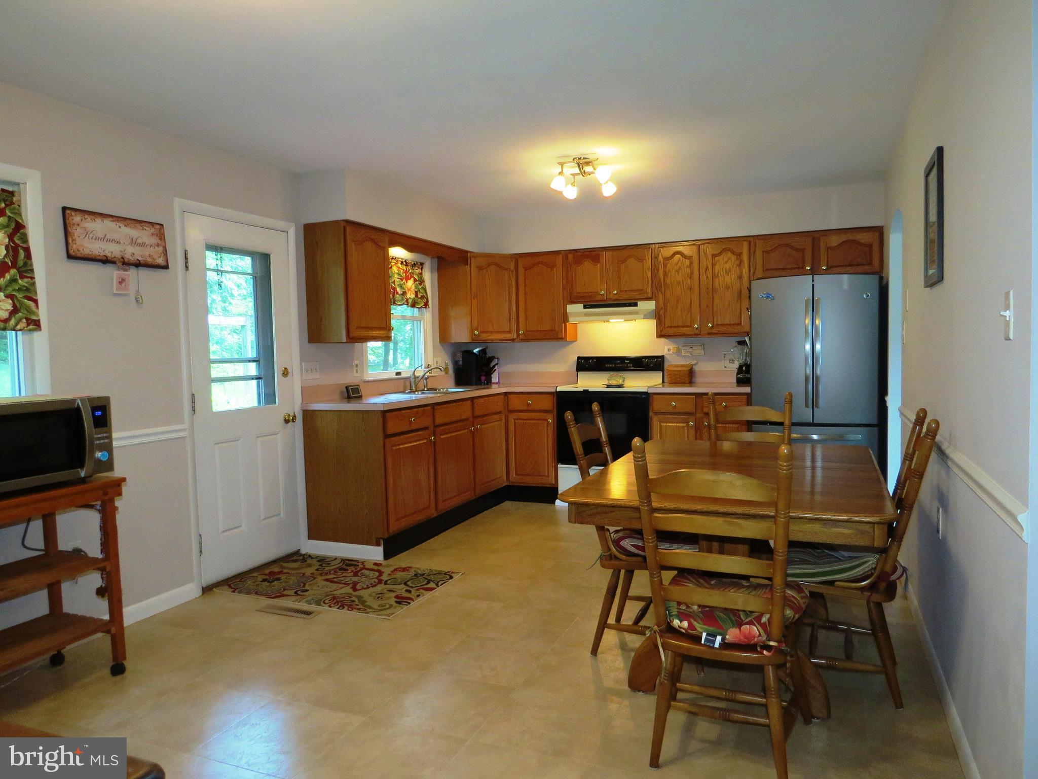 3165 Falls Road Hampstead, MD 21074 - Photo 5 of 30 a kitchen with a table chairs refrigerator and a sink