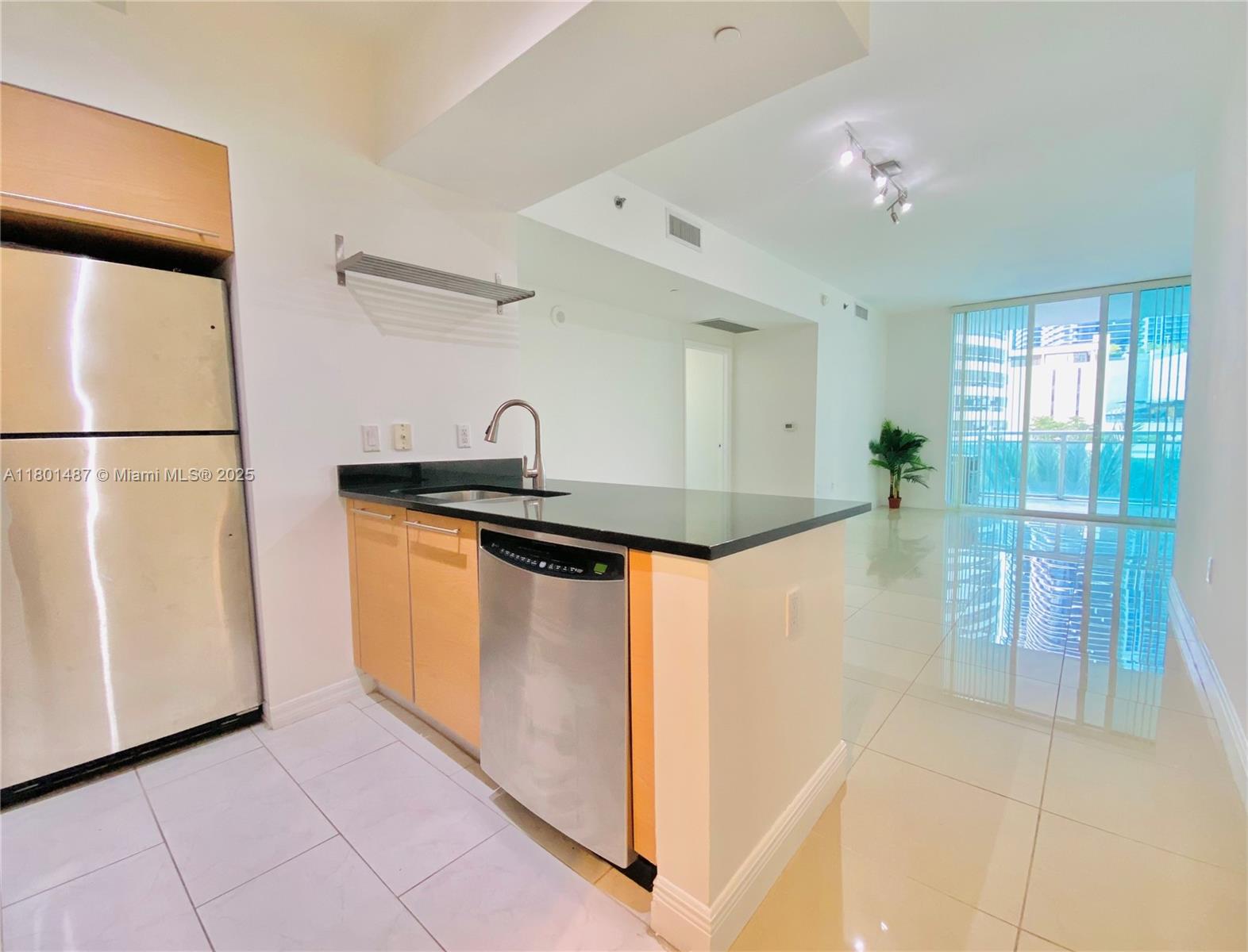 a kitchen with stainless steel appliances granite countertop a refrigerator and a sink
