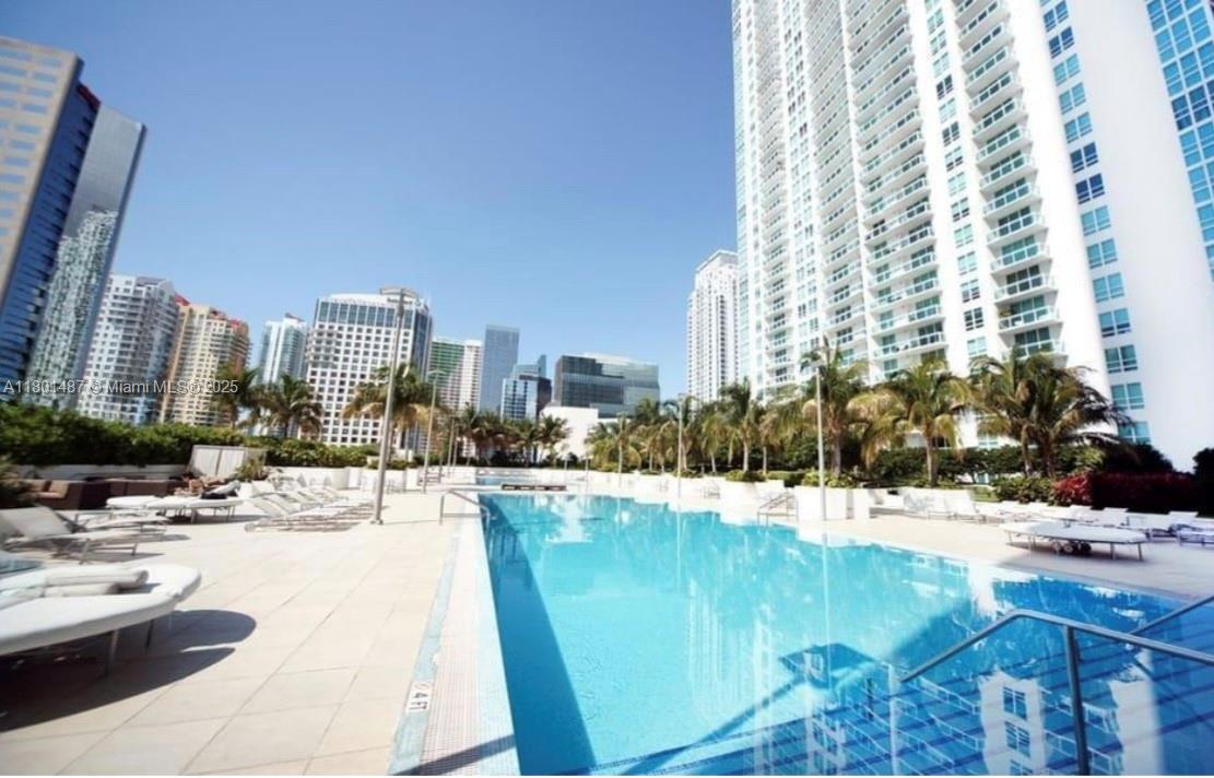 950 Brickell Bay Drive, Unit 401 Miami, FL 33131 - Photo 17 of 28 a swimming pool with outdoor seating and city view
