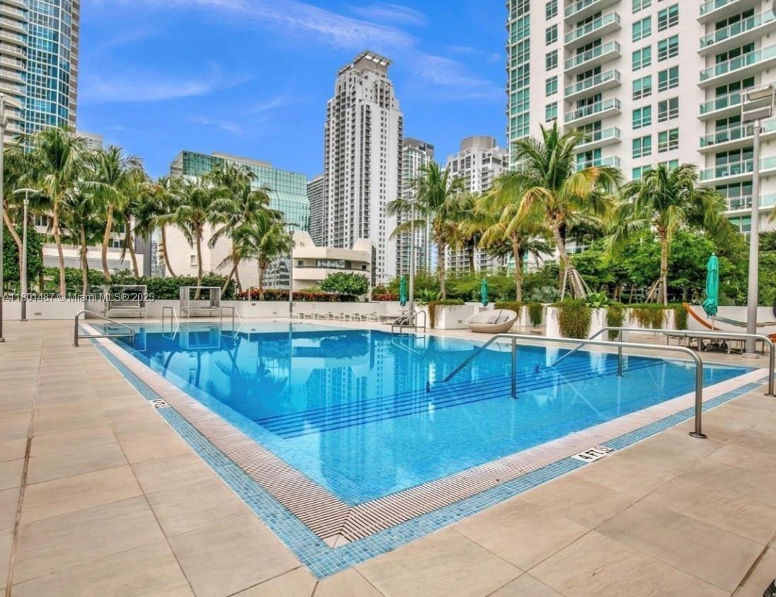950 Brickell Bay Drive, Unit 401 Miami, FL 33131 - Photo 18 of 28 a view of swimming pool with outdoor seating and plants