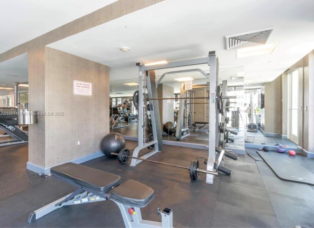 950 Brickell Bay Drive, Unit 401 Miami, FL 33131 - Photo 23 of 28 a room with gym equipment and a glass door shower